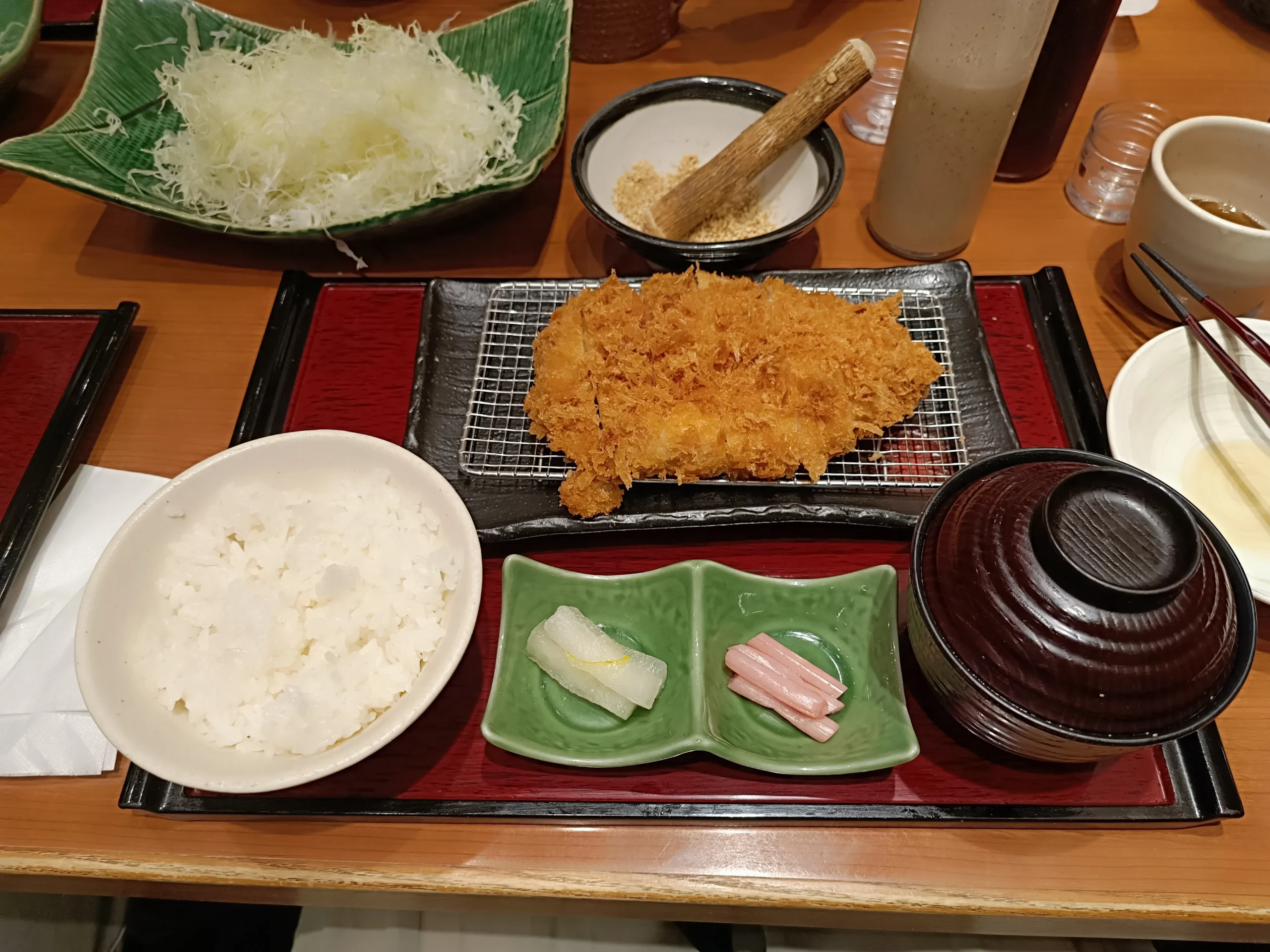 Plateau avec une assiette de porc frit accompagné de condiments, de soupe miso et de riz