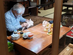 Artisan sculpteur japonais en train d’appliquer son art sur des statuettes représentant des chevaux