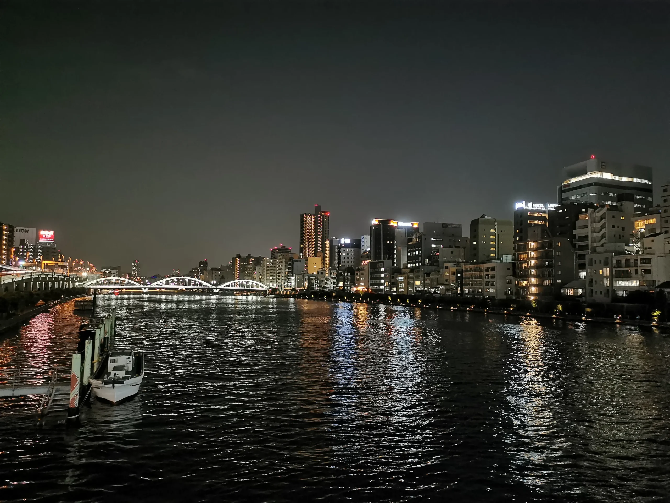 Vue de nuit sur la rivière Sumida avec les immeubles en arrière-plan à Asakusa