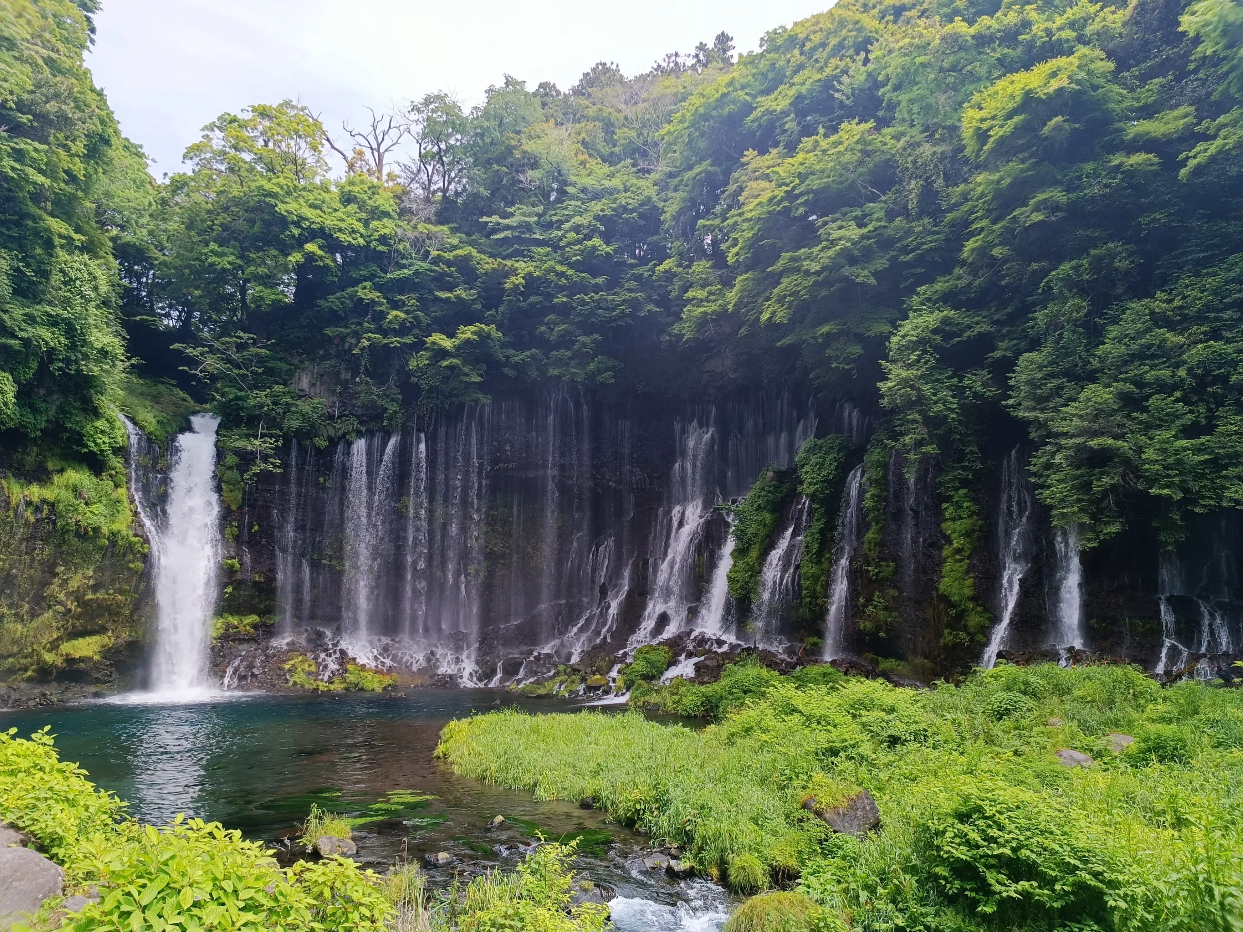 Nombreuses chutes d’eau sur un lac avec une forêt luxuriante autour