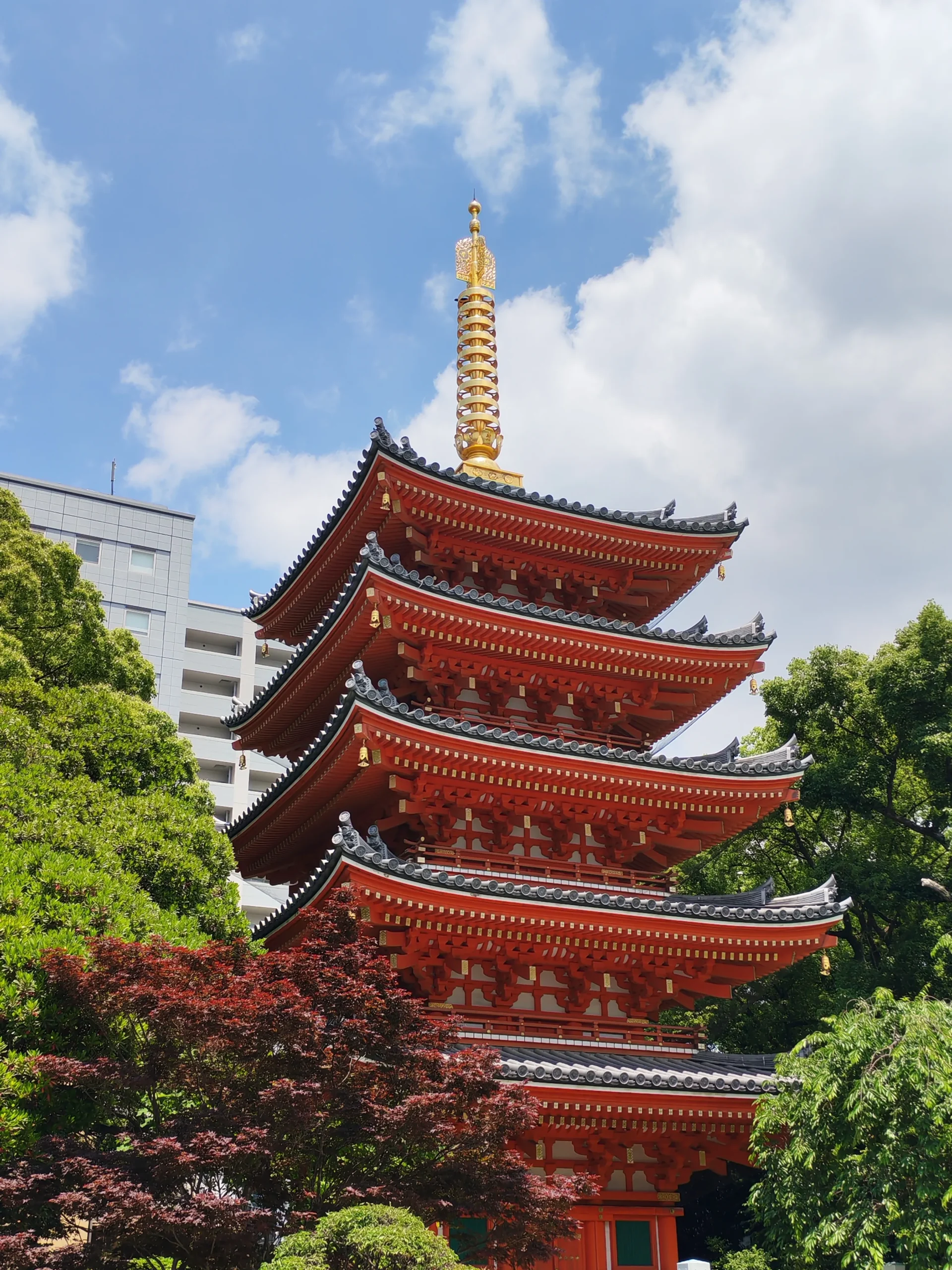 Tour du Tochoji tout en rouge entouré d’arbres à Fukuoka