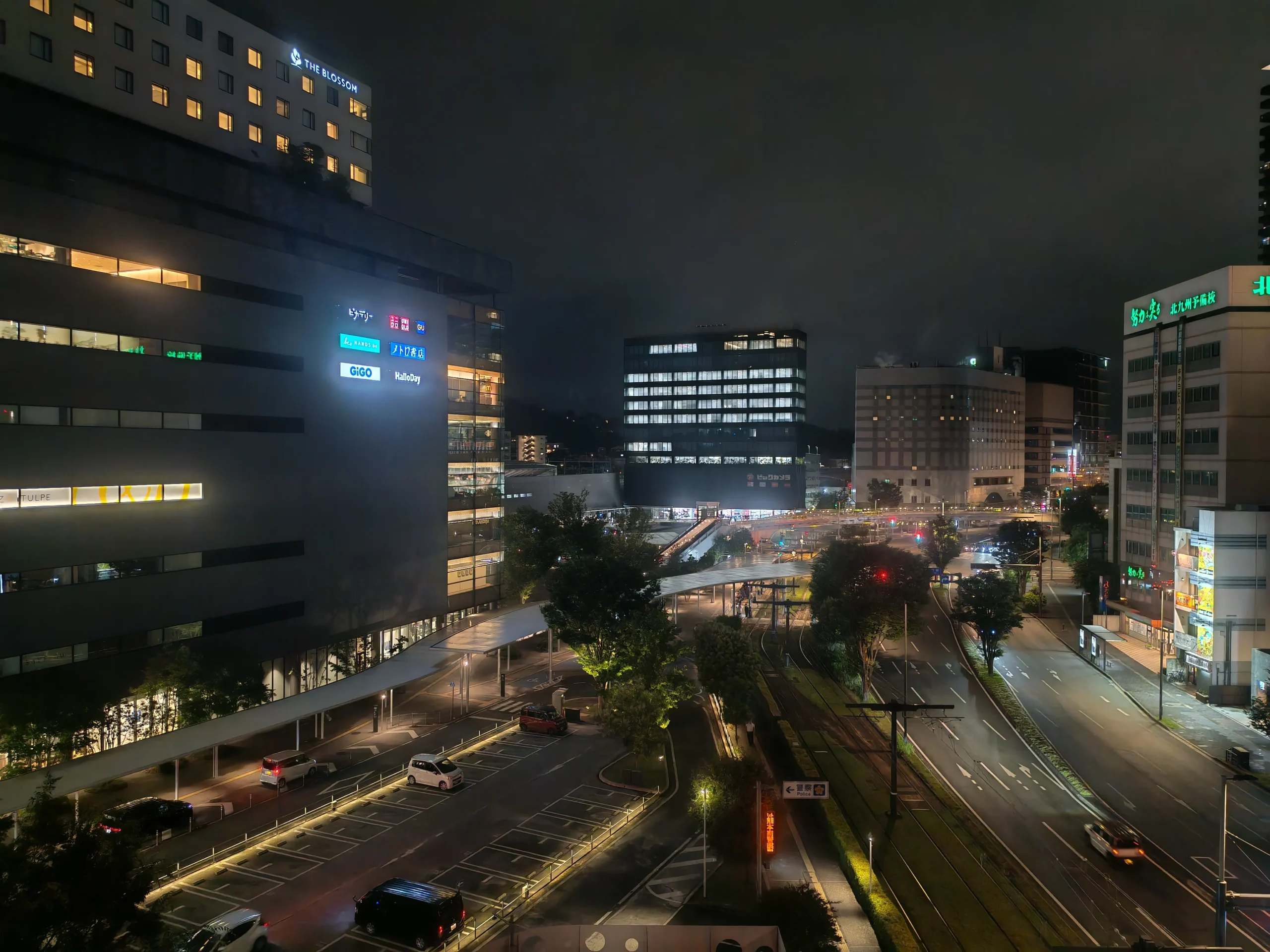 Photo prise de nuit du quartier de la gare de la ville de Kumamoto avec ses buildings et voitures