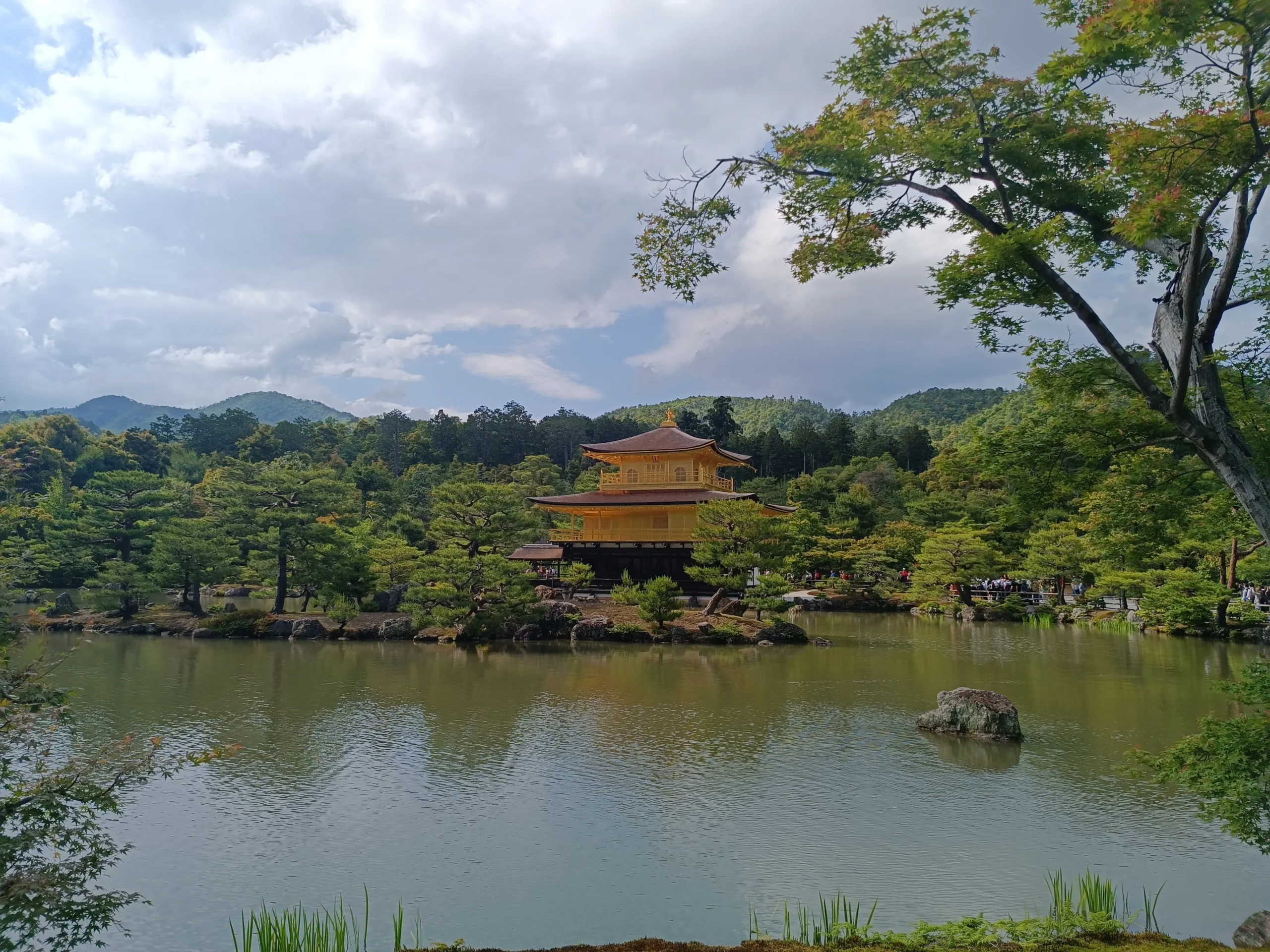 Le pavillon d’or au milieu d’un lac avec des arbres en arrière-plan