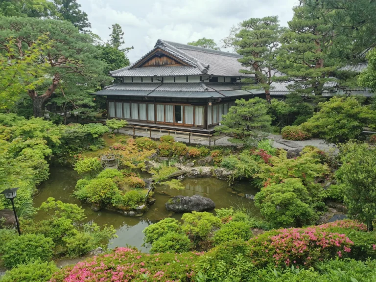 Pavillon traditionnel japonais entouré d’étang et de végétation à Yoshiki-en